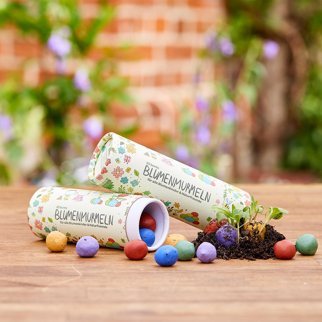 25 colorful flower marbles in a tin